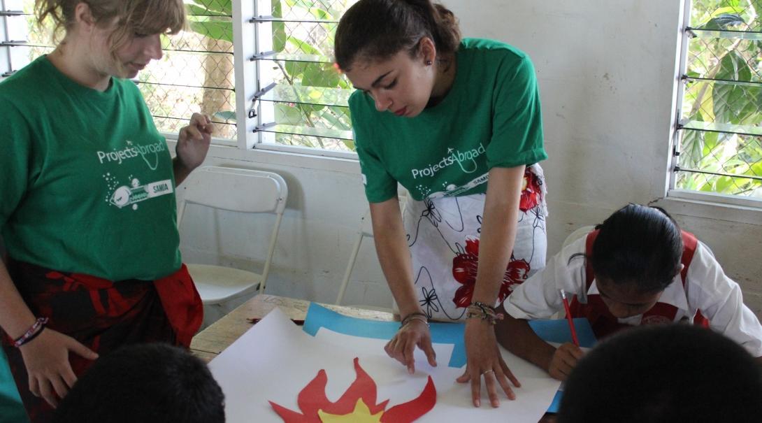 Projects Abroad volunteers teach children at local school during their cultural immersion in Samoa. Volunteers in a village in Samoa teach children at a local school.